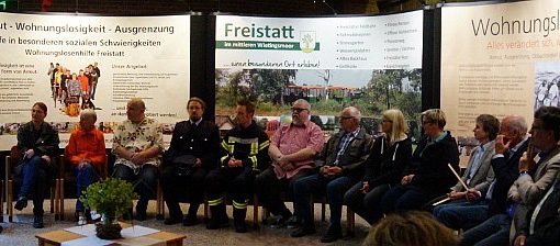 Einwohner*innen vor den Schautafeln zu Wohnungslosenhilfe, Freistatt und dem Projekt Wohnungslosentreffen