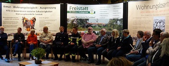 Einwohner*innen vor den Schautafeln zu Wohnungslosenhilfe, Freistatt und dem Projekt Wohnungslosentreffen