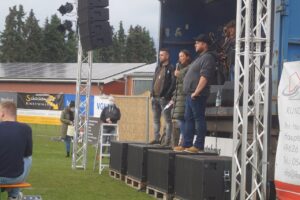 "Mag" von der Band Westwärts, Elana Devermann, eine Freundin von Miriams Familie und Michael Weiß, der Freund von Miriams Ehemann (v. l.) bei der Begrüßungsrede. Im Hintergrund steht schon die Band Wippsteert bereit.